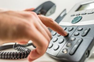 Closeup of male hand dialing a phone number making a business or personal phone call.