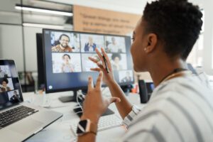 Businesswoman vide chatting with coworkers at computer in office