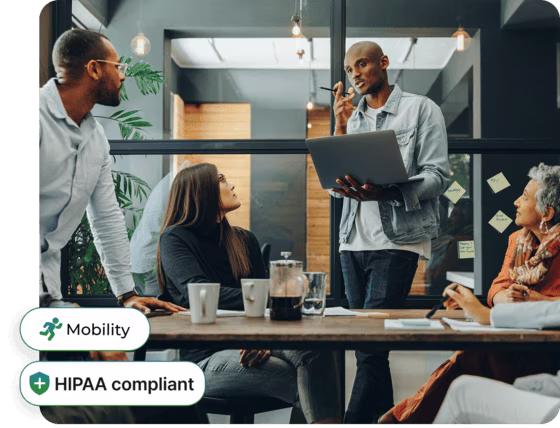 Small business team collaborating in a modern office, with Phone.com mobility and HIPAA compliance feature callouts
